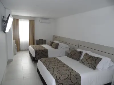 a hotel room with two beds and a window at Hotel Arawak Plaza in Sincelejo