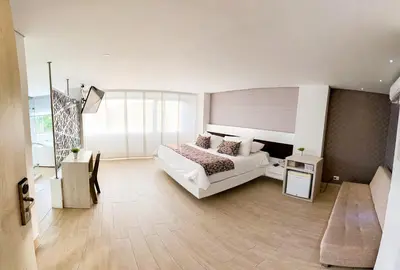 a large bedroom with a bed and a large window at Hotel Arawak Plaza in Sincelejo