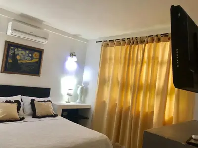 a bedroom with a bed and a yellow curtain at host Casa Don Arturo in Santa Marta
