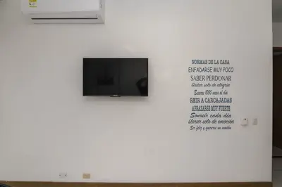 a tv on a white wall with a sign on it at Magico Apartamento Frente al Mar 2 Habitaciones PAZ124 in Coveñas