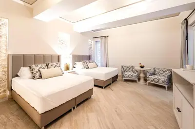 a bedroom with two beds and a table and chairs at Eurostars Marqués de Villalta in Cartagena de Indias