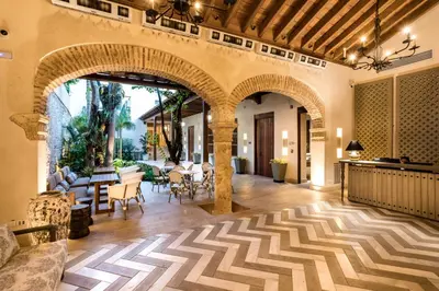 an indoor living room with an archway with tables and chairs at Eurostars Marqués de Villalta in Cartagena de Indias