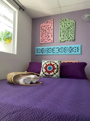 a bedroom with a purple bed with purple sheets and pillows at Casa San Juan in Cartagena de Indias