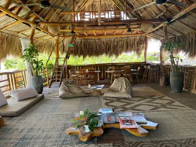 a living room with a table and chairs in a hut at Eco Xata in Santa Veronica