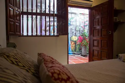 a bedroom with a bed and a door to a patio at Casa San Benito Abad in Cartagena de Indias