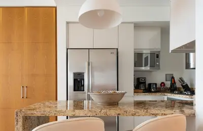 a kitchen with a counter with chairs and a refrigerator at Classy 1 BR, Pool, Gym near Downtown Cartagena by Huespedia in Cartagena de Indias