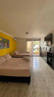 two beds in a room with a kitchen and a room with two beds at Hotel Balcones de Bocagrande in Cartagena de Indias