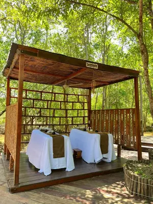 a wooden gazebo with two tables and chairs at Santo Manglar Cartagena Life Wellness Spa Hotel in Cartagena de Indias