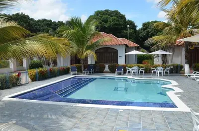 a pool with chairs and umbrellas next to a house at Condominio Atlantis in Coveñas