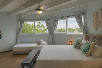 a bedroom with two beds and two windows at Fragata Island House in Isla Grande