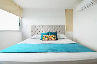 a bedroom with a large bed with blue and white at Apartamentos Palmetto - Frente al Mar in Cartagena de Indias