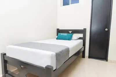 a bedroom with a bed with a blue pillow on it at Hotel Itaka in Soledad