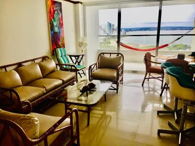 a living room with couches and chairs and a large window at IV 2 bedroom apartment in Cartagena de Indias
