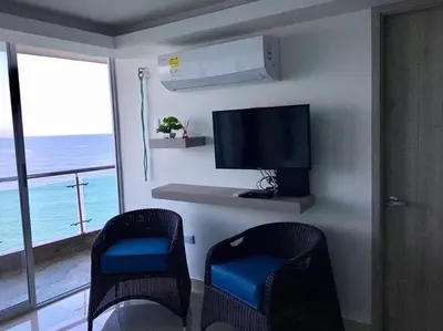 a living room with two chairs and a flat screen tv at apartamento 807 moderno en el laguito, vista al mar in Cartagena de Indias