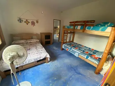 a bedroom with two bunk beds and a fan at Rainbow Hostel in San Bernardo del Viento