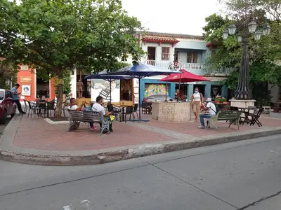 a group of people sitting on a bench on a street at APTO INTERIOR in Cartagena de Indias