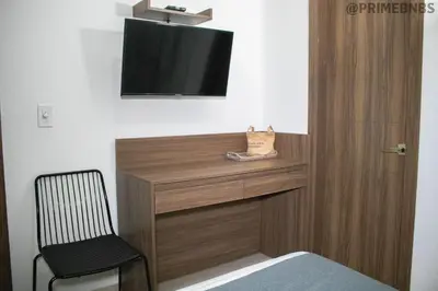 a room with a desk with a tv and a chair at Brand New - Prime Location For All Budgets - Executive & Luxury in Barranquilla