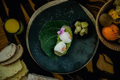 a plate with a piece of bread with a flower on it at Éteka Slow Beach Hotel Adults Only in Cartagena de Indias