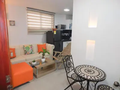 a living room with a couch and a table and chairs at STUDIO DELFINES / BOCAGRANDE in Cartagena de Indias