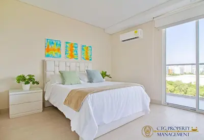a white bedroom with a bed and a large window at Martinique Cartagena, Beautiful 1 & 2 Bedroom Apartments in Cartagena de Indias