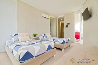 a bedroom with two beds and a television in it at Martinique Cartagena, Beautiful 1 & 2 Bedroom Apartments in Cartagena de Indias