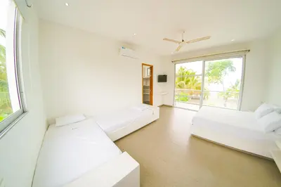a white room with two beds and a window at Quinta del Mar La Joya in Tolú