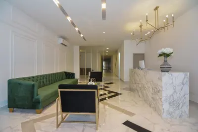 a living room with a green couch and a table at Hotel OR Suites in Barranquilla