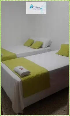 two beds with green pillows sitting next to each other at HOTEL CASA GARCES in Cartagena de Indias
