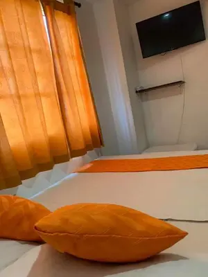two orange pillows on a bed in a room at Hotel Torres del Parque No1 in Soledad