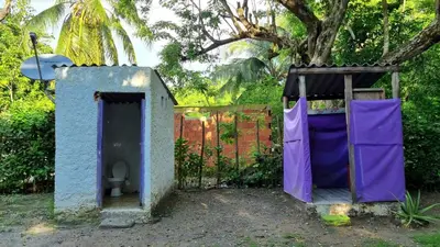 an out house with a purple door and a toilet at Eco-Camping El Frutal in Isla Grande