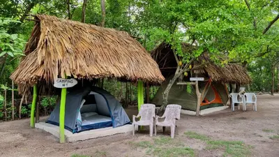 a small tent with chairs and a thatch roof at Eco-Camping El Frutal in Isla Grande