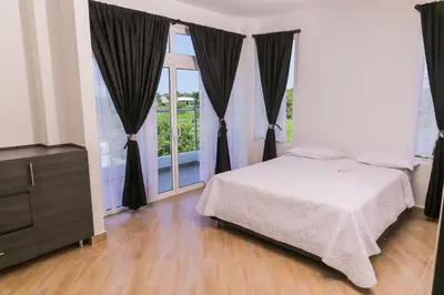 a bedroom with a bed and a large window at VILLA MANDALAY in Santa Veronica