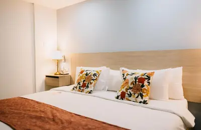a bedroom with a large bed with white sheets and pillows at Casa Franco Hotel in Cartagena de Indias