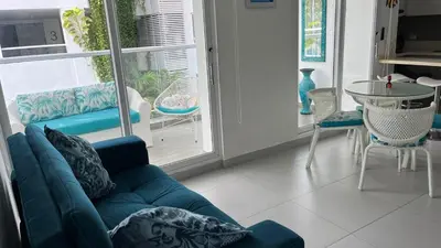 a living room with a blue couch and a table at Spiaggia Morros Direct Beach Access in Cartagena de Indias