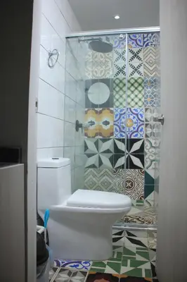 a bathroom with a toilet and a tiled wall at Casa St James in Cartagena de Indias
