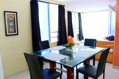 a dining room with a table and chairs and a bedroom at 2 Alcoves Beachfront 2-19C air-wifi in Cartagena de Indias