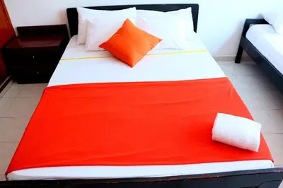 a bed with an orange and white blanket on it at Sea View Apartment 1-19C Air Wifi in Cartagena de Indias
