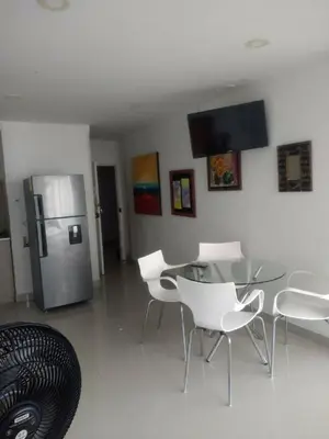 a dining room with a glass table and a refrigerator at Sea View Apartment 1-5C air wifi in Cartagena de Indias