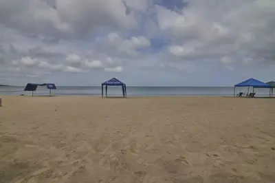 three blue shelters on a beach with the ocean at Mágico Apartamento Frente al Mar 3 Habitaciones PV21 in Coveñitas