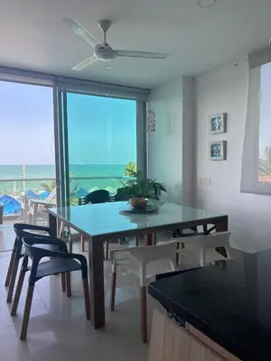 a dining room with a table and chairs and a view of the ocean at Mágico Apartamento Frente al Mar 3 Habitaciones PV21 in Coveñitas