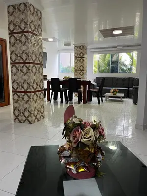 a living room with a table with a bouquet of flowers at Villa Santos Apartaestudios in Barranquilla