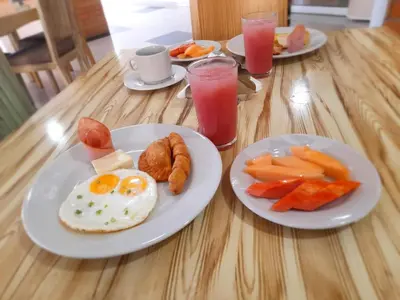 a wooden table with plates of breakfast foods and drinks at Hotel Torre del Prado in Barranquilla