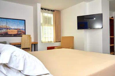 a bedroom with a bed and a tv on the wall at Hotel Torre del Prado in Barranquilla