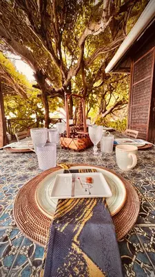 a table with a laptop on a table under a tree at Isla Única- Islas del Rosario in Isla Grande