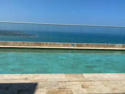 a swimming pool with blue water in front of a fence at Apartamento Frente al Mar in Cartagena de Indias