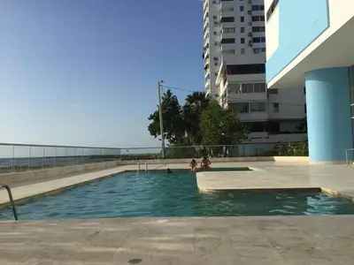 a swimming pool with people in it next to a building at Apartamento Frente al Mar in Cartagena de Indias