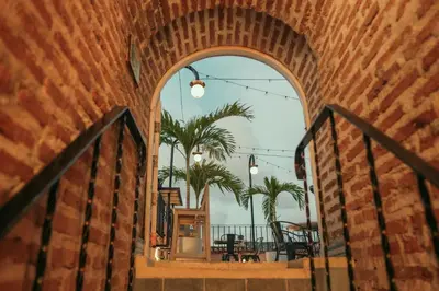 an archway leading to a patio with palm trees at CASA MOVIDA HOSTEL in Cartagena de Indias