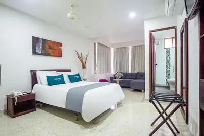 a bedroom with a bed and a living room at Ayenda Hotel Carivdi in Sincelejo