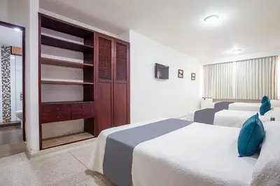 a bedroom with two beds and a closet at Ayenda Hotel Carivdi in Sincelejo
