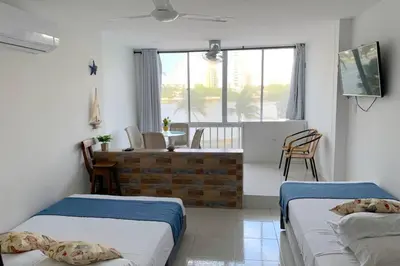 a bedroom with two beds and a room with a table at Apartamento cerca de playas y zonas turísticas in Cartagena de Indias